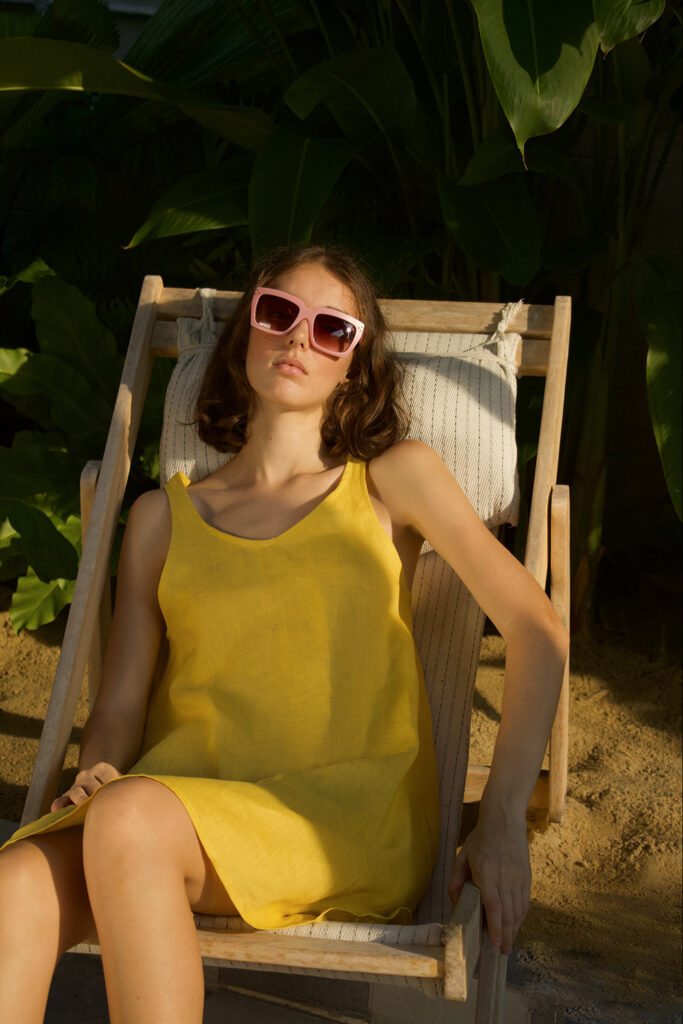 alla on a beach chair wearing a yellow beach dress